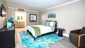 Un dormitorio moderno con cama, escritorio, silla y una mesita.