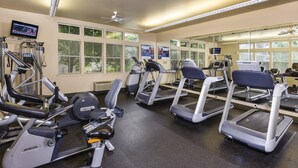 A gym with treadmills, elliptical machines, and weight equipment.