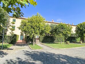 A courtyard with a building, trees, and a gravel path. - Cinquantina by Interhome (Cecina)