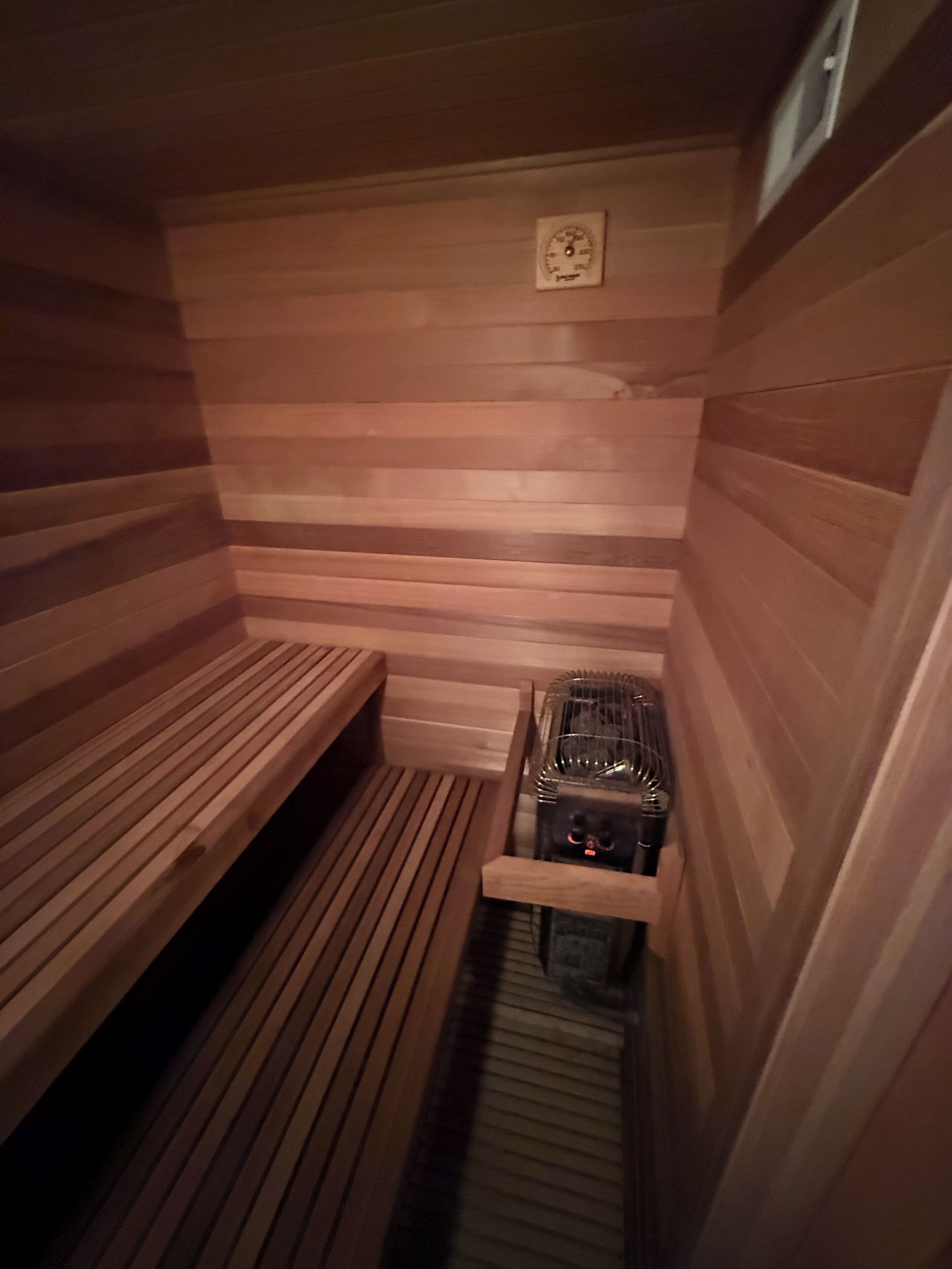 A sauna with wooden benches and a steam generator.