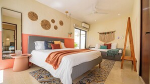 A modern bedroom with a large bed, a standing fan, and a wooden easel. - Casa Kolibrí - 8 Bedrooms + Pool + Outdoor Kitchen + Coworking (Mérida)
