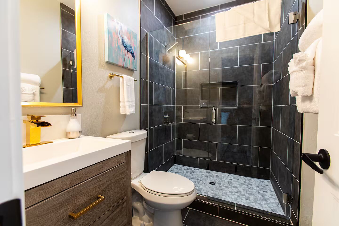 A modern bathroom with a shower, toilet, and vanity.