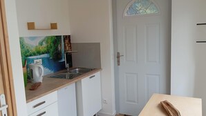 Una cocina con encimera de madera, un lavamanos y un cuadro de un paisaje.