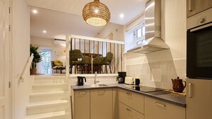 A modern kitchen with a built-in oven, a coffee maker, and a kettle on the counter. - Cottage 58B (Twisk)