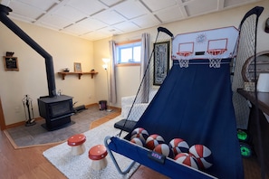 Une pièce avec un panier de basket, une cheminée et un toboggan.