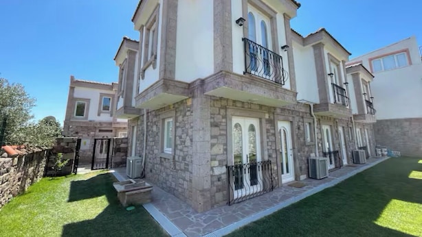 A two-story house with a stone facade, large windows, and a balcony. - MyWayHoliday (Ayvalik)