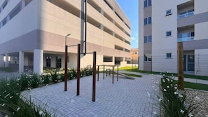 A multi-story parking garage with a covered walkway and exercise equipment. - Solarium Beach Club - Apartamento T1.505 (Itapoá)