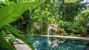 Una vista despejada de una piscina rodeada de exuberante vegetación.