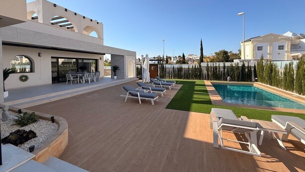 A modern outdoor pool area with lounge chairs, a dining area, and a view of the surrounding neighborhood. - 3 Bed Villa - Sleeps 6 - Private Pool - Parking (Rojales)