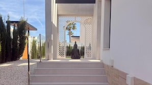 A modern entrance with a statue, steps leading up to a covered area, and a clear view of the sky. - 3 Bed Villa - Sleeps 6 - Private Pool - Parking (Rojales)