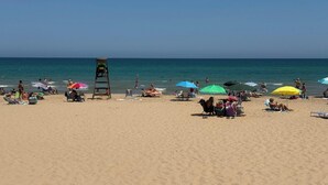 A beach with people sunbathing, umbrellas, and a lifeguard tower. - 3 Bed Villa - Sleeps 6 - Private Pool - Parking (Rojales)