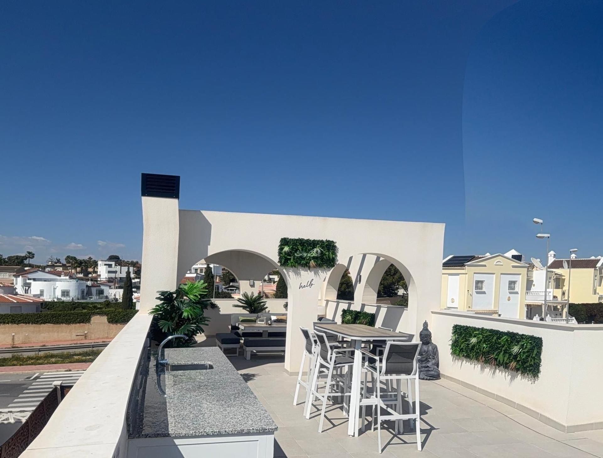 Une terrasse extérieure avec un espace salon, un élément décoratif aquatique et une statue de Bouddha.
