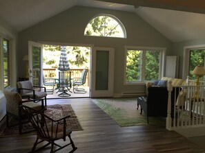 Un espacio habitable amplio con un ventanal grande, un patio con mobiliario exterior y vistas al exterior.