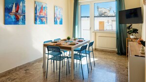 Spiseplads med et bord, stole og kunst på væggene.