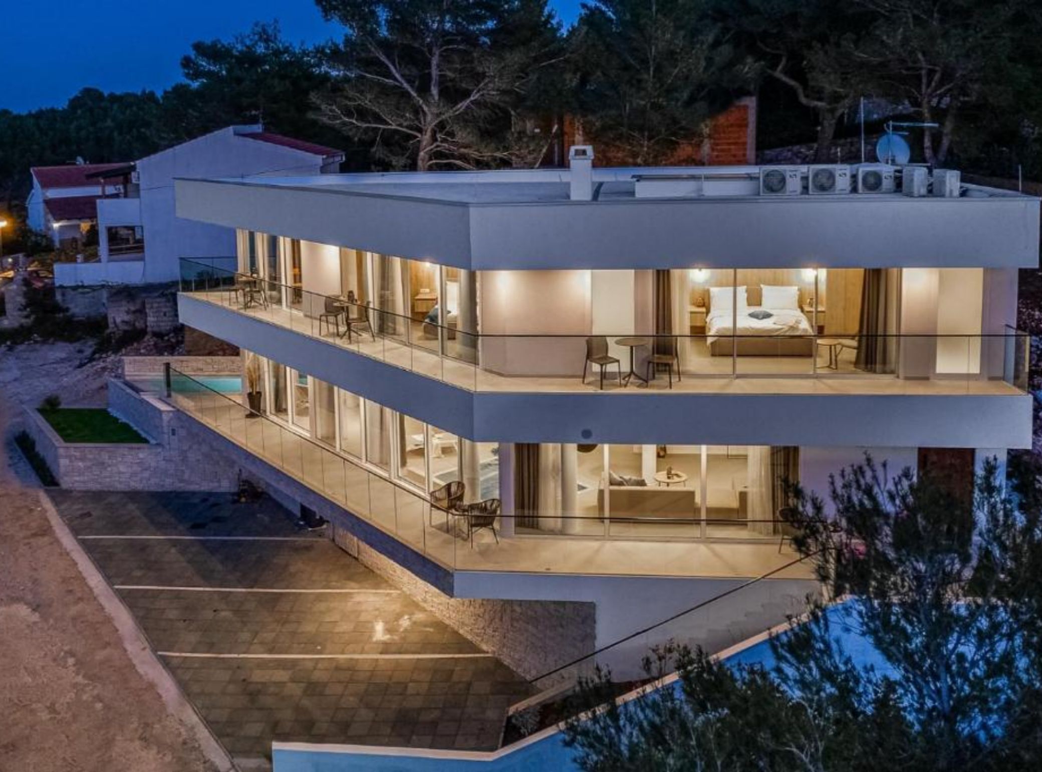 A modern two-story building with a balcony and a pool area.