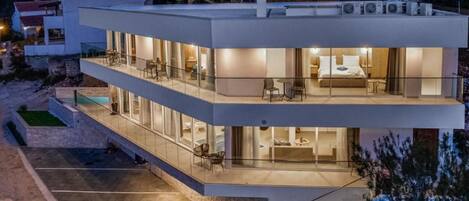 A modern two-story building with a balcony and a pool area.