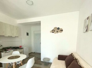 Ein modernes Apartment mit Küche, Essbereich und Wohnzimmer.