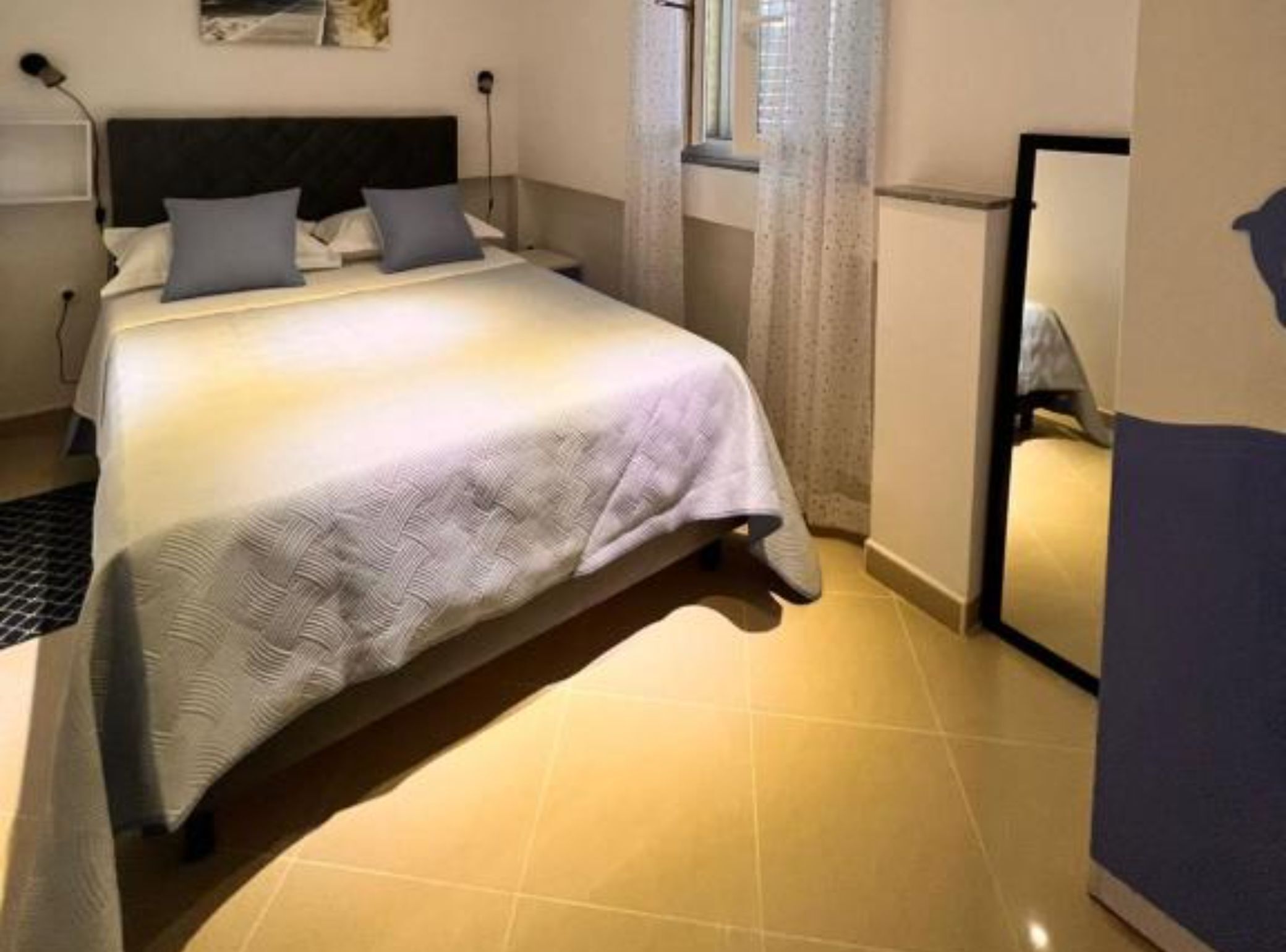 A neatly made bed with a patterned bedspread, a headboard, and two pillows.