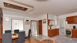 A modern living room with a dining area, a kitchen, and a small round table. - Privlaka Sunset Apartments (Privlaka)