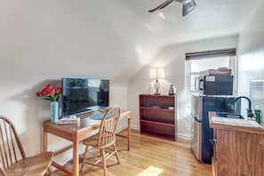 A compact kitchen with a microwave, refrigerator, and a small dining area with a table and chairs.