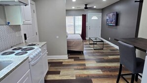 Una cocina moderna con electrodomésticos blancos, un salpicadero con diseño de espiga y suelo de parqué de madera.