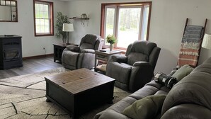 A living room with a fireplace, two recliners, a coffee table, and a lamp.