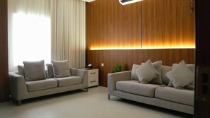 Suite Confort, vistas a la ciudad | Zona de estar | Televisión de pantalla plana de 30 pulgadas con canales digitales