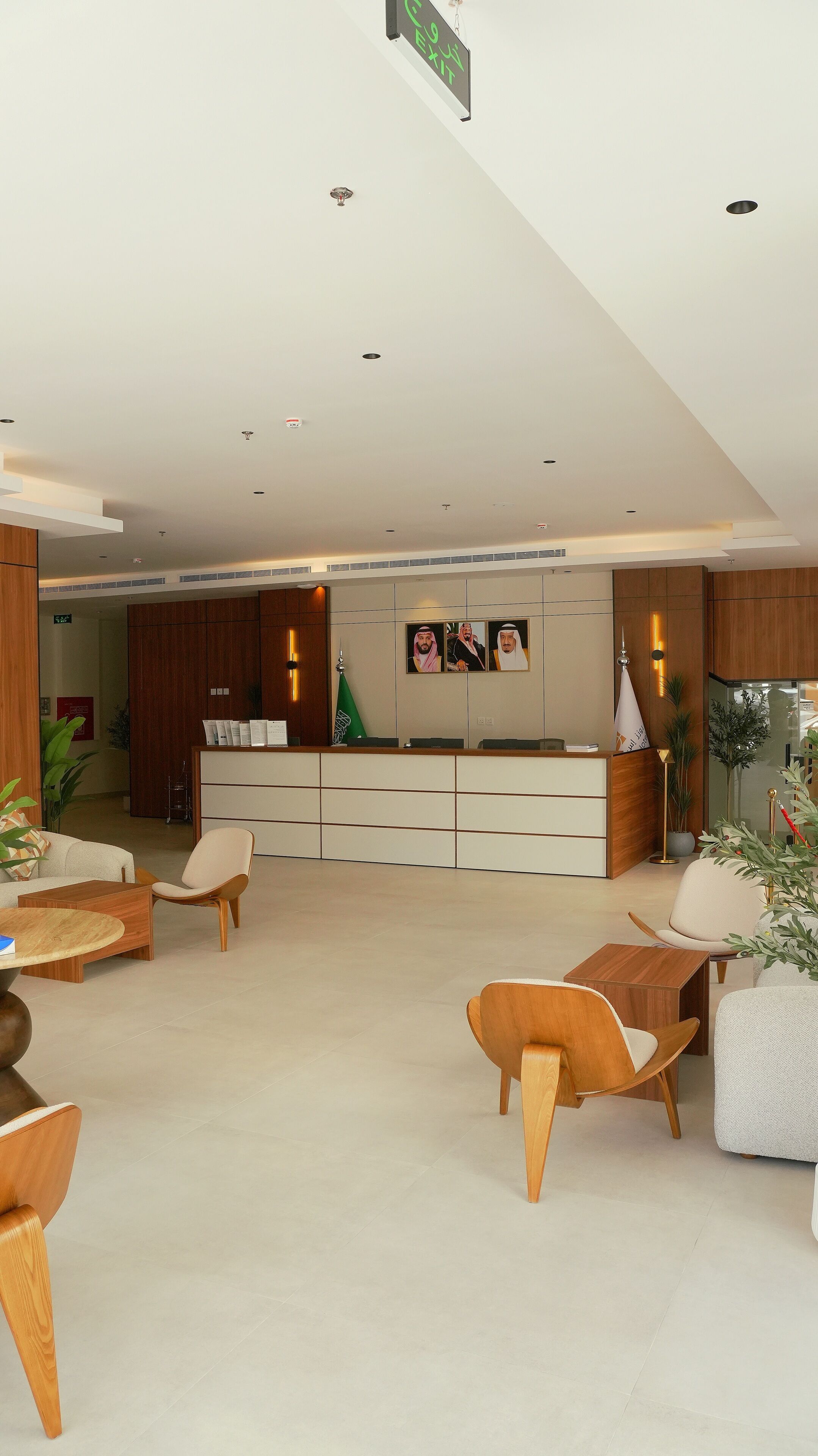 Un área de recepción moderna con mostrador, asientos y un panel con fotografías.