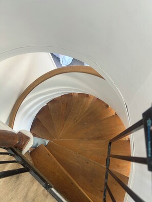Eine Wendeltreppe mit Holzdielen und weißen Wänden.