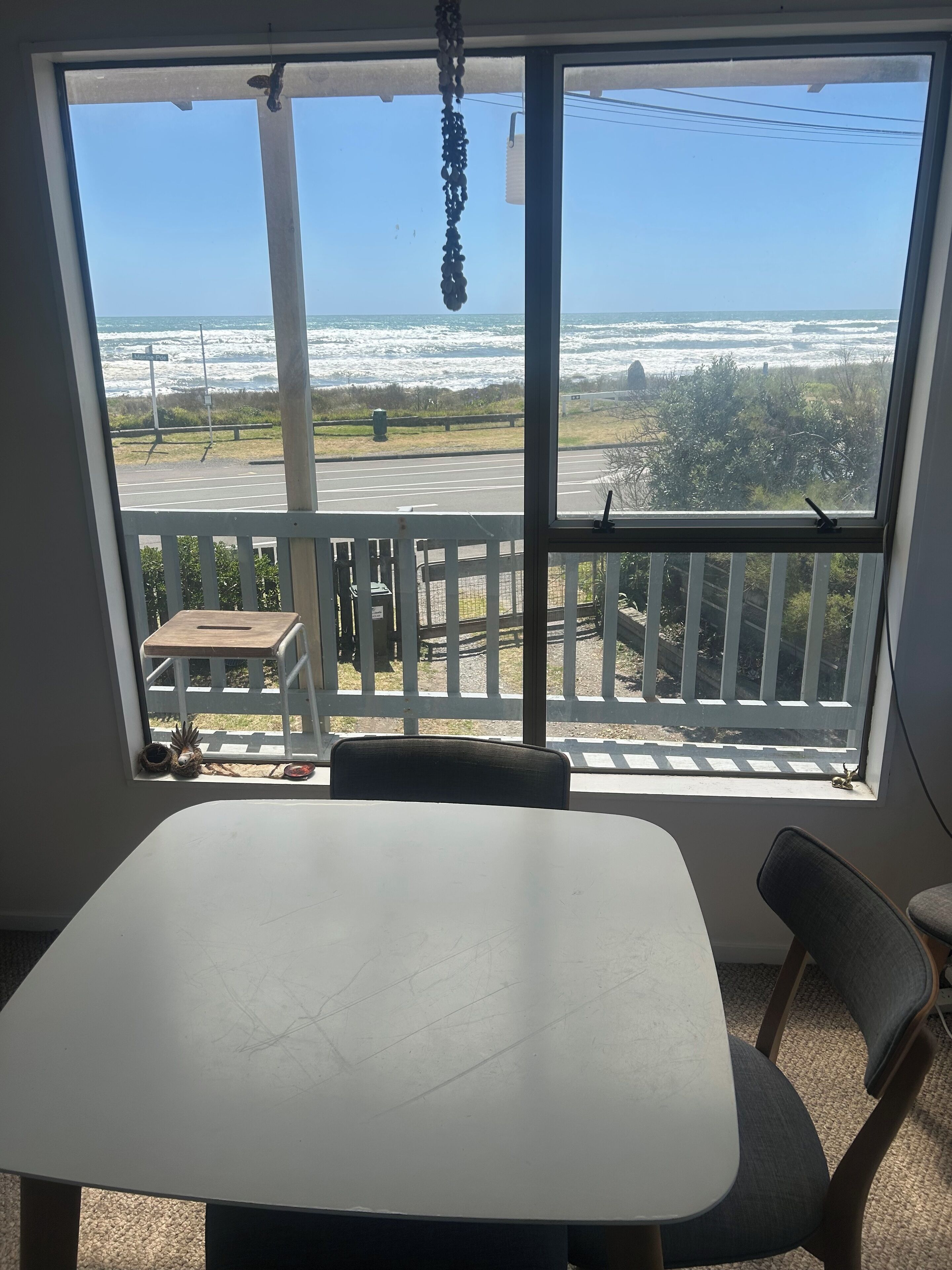 Una stanza con una grande finestra vista spiaggia e mare.