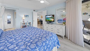 Een slaapkamer met een bed, een televisie, een bureau en uitzicht.