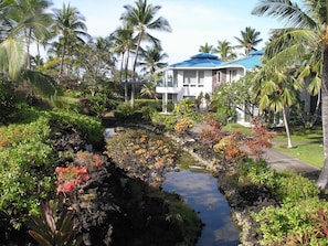 A resort with a pool, palm trees, and a building with a blue roof. - Club Wyndham Mauna Loa Village- 1 bedroom Condo (Kailua-Kona)