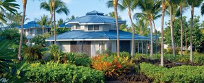 A multi-story building with a blue roof, surrounded by lush tropical vegetation. - Club Wyndham Mauna Loa Village- 1 bedroom Condo (Kailua-Kona)