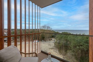 A balcony with a view of the sea, wooden railings, and a chair. - Apartment With Direct sea View (Rewal)