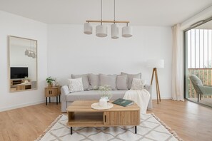 A modern living room with a sofa, coffee table, and a large mirror. - Apartment With Direct sea View (Rewal)