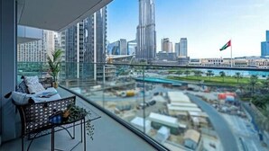 A balcony with a view of the Burj Khalifa and other buildings, a flag, and a construction site. - Vogue| Opera Grand near Dubai Mall | Burj Khalifa (Dubai)