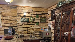 A bar area with a stone wall, a jukebox, a red bar stool, and a wooden cabinet. - Cozy 1-bedroom 1st floor in beautiful Pittsburgh with AC (Pittsburgh)
