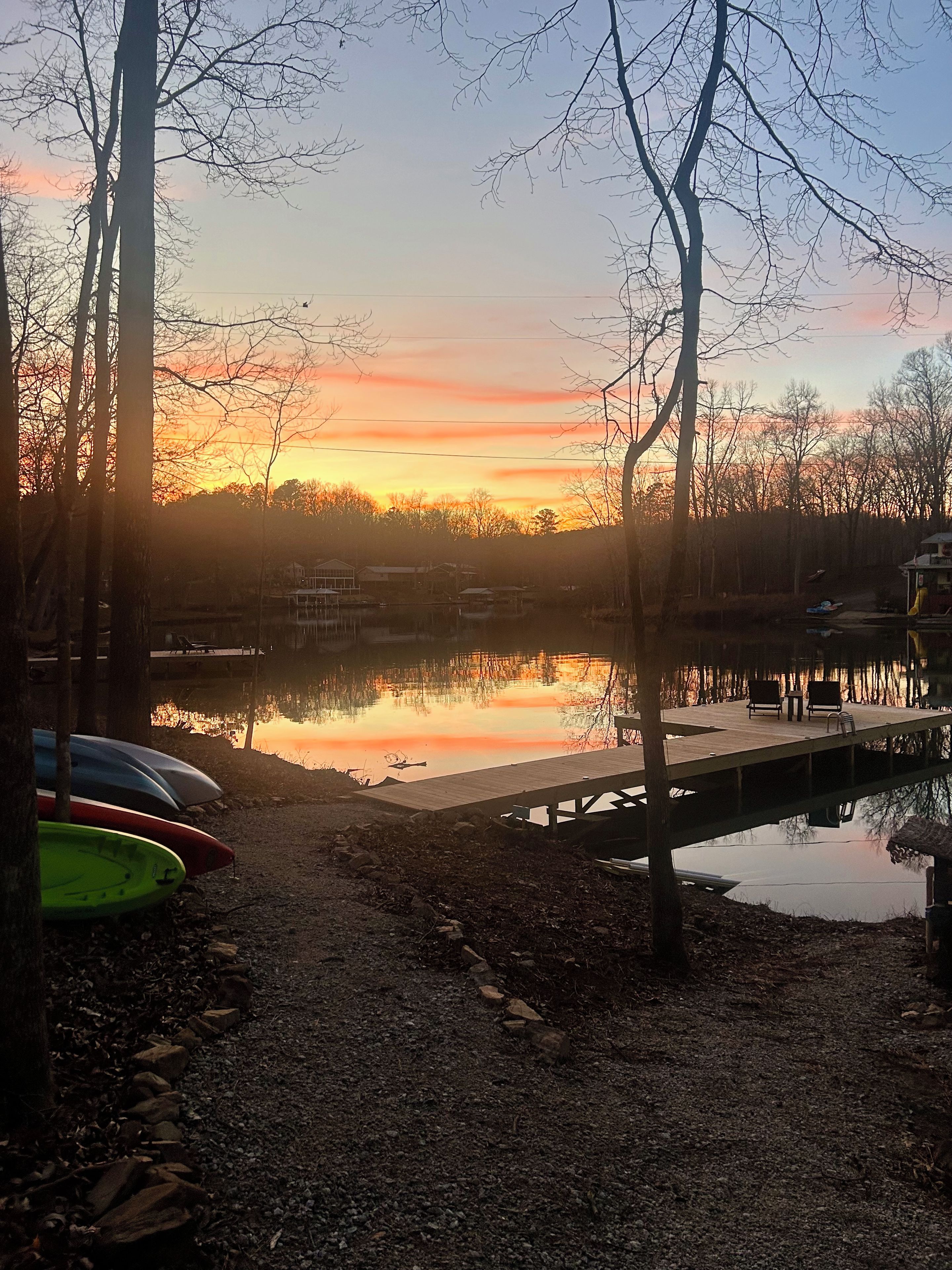 Une vue paisible sur un lac, avec un quai en bois et des bateaux.
