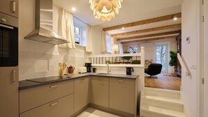 A modern kitchen with a built-in oven, a coffee maker, and a kettle on the counter.
