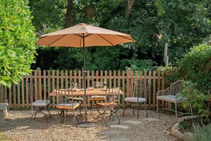 A wooden deck with a table and chairs, surrounded by a wooden fence and greenery. - Perfect location for city and countryside (Batheaston)