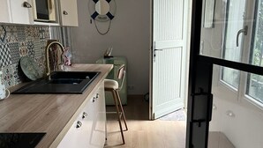 Una cocina moderna con encimera de madera, un lavamanos y un refrigerador de estilo vintage.