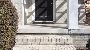 A house with a white exterior, a black front door, and a number 1418 above the door.
