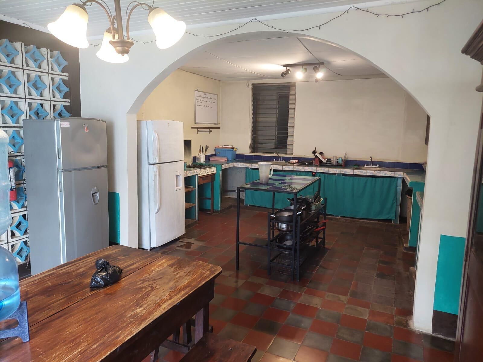 A compact kitchen with a refrigerator, stove, and a dining area with a bench.