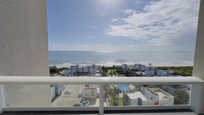 A balcony with a view of the ocean and a coastal town. - Solarium Beach Club -Apartamento T1.1003 (Itapoá)