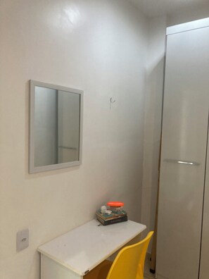 A small room with a white desk, a mirror, a yellow chair, and a wardrobe. - Complete apartment behind the Shopping Mall (Belém)