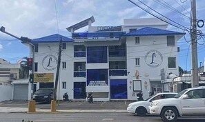 Un bâtiment doté d’un toit bleu et de murs blancs, avec un grand logo circulaire sur la façade.