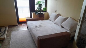 A bedroom with a bed, a rug, a potted plant, and a window. - Spacious apartment for up to 8 people - family-friendly, pets welcome (Schneverdingen)