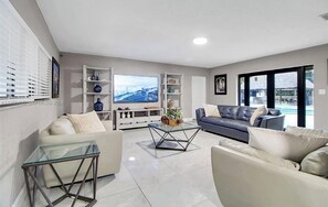A modern living room with a sofa, a glass coffee table, and a TV. - El bosque encantado (Miami)