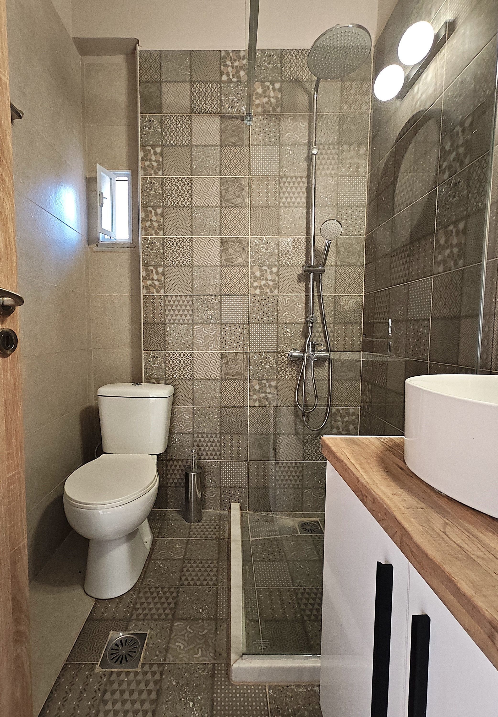A bathroom with a toilet, shower, and sink.