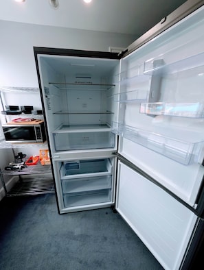 An open refrigerator with multiple shelves and a fresh box compartment.